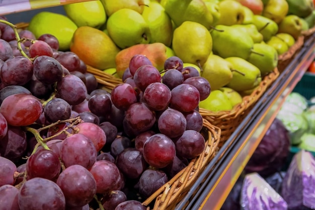 ripe juicy fruits on the counter in the store. ripe red grapes and juicy yellow pears