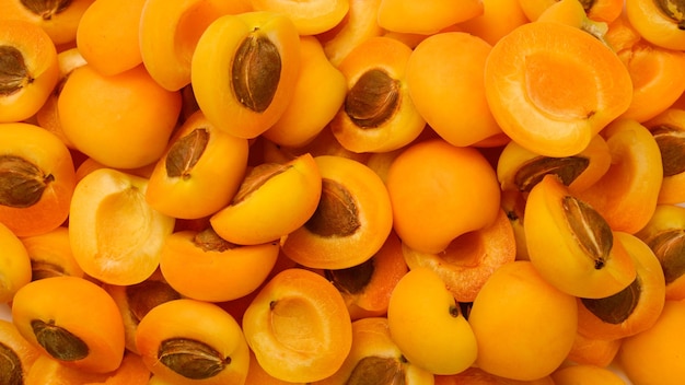 熟したジューシーなオレンジ色のアプリコットは、果物の背景をスライスします。
