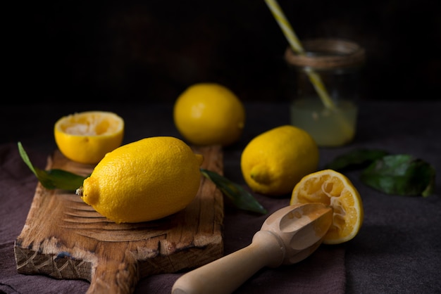 Ripe juicy organic lemons on a wooden board, dark background, close up