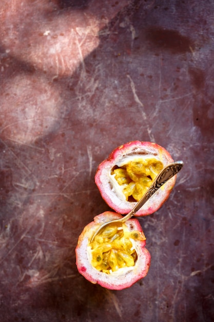 Ripe juicy passion fruit on a red concrete table