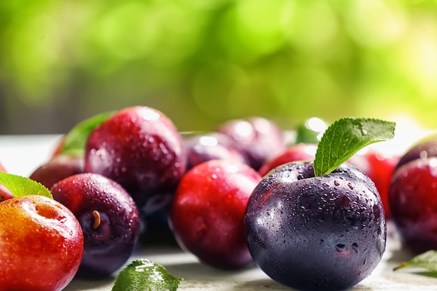 Ripe juicy plums on table