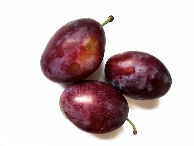 ripe juicy plums on white background