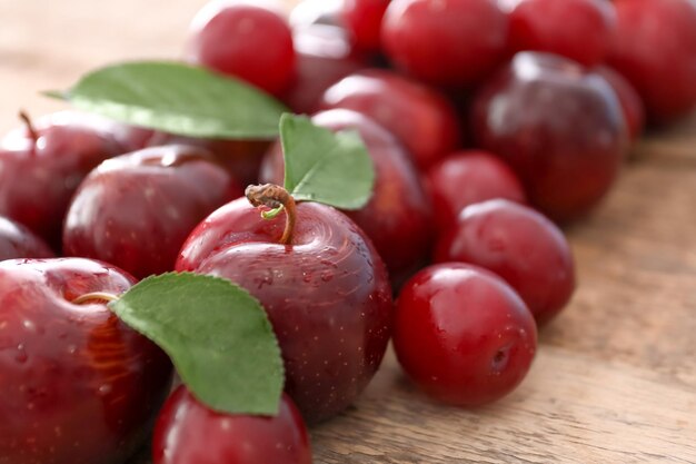 Ripe juicy plums on wooden table