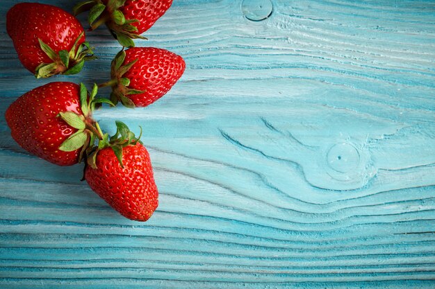 Ripe juicy strawberries on a wooden table.