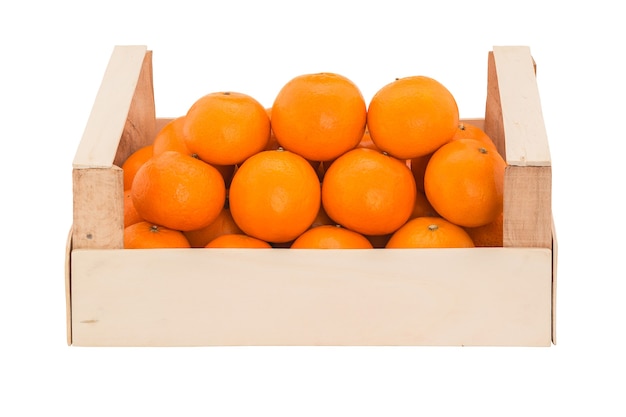 Ripe juicy tangerines in a wooden box stacked as pyramid Front view