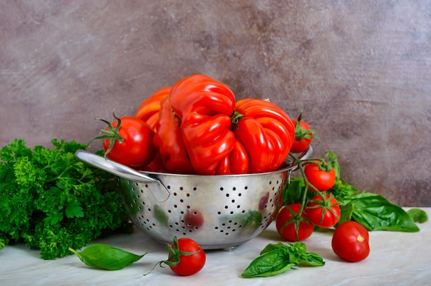 Ripe juicy tomatoes of different varieties green fragrant basil on the table Italian Cuisine