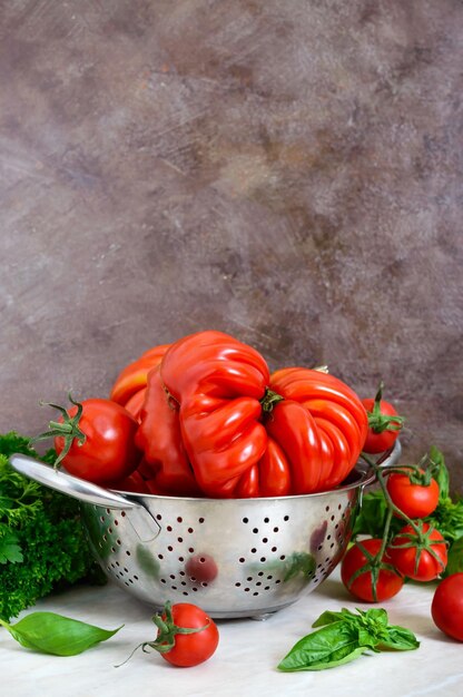 Pomodori succosi maturi di diverse varietà basilico verde profumato sul tavolo cucina italiana