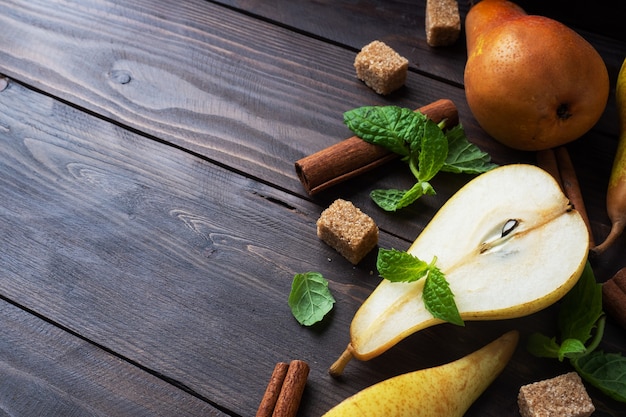 Ripe juicy yellow pears with cinnamon on wooden