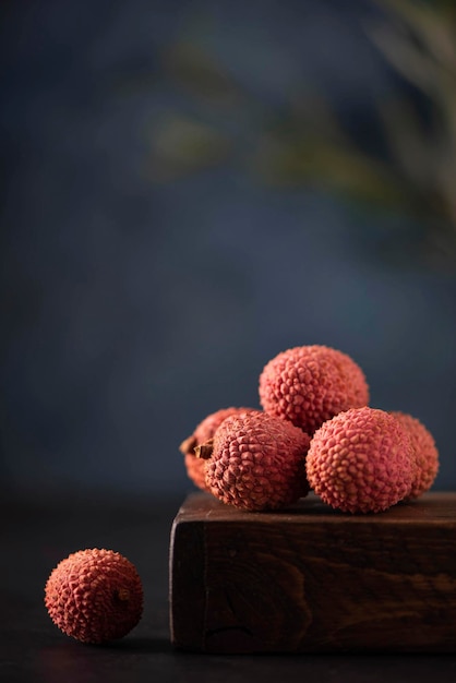 Ripe large lychees fruit on a wooden board, close-up