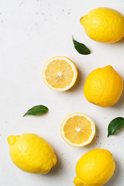 Фото Спелые лимоны лежат с листьями на белом фоне