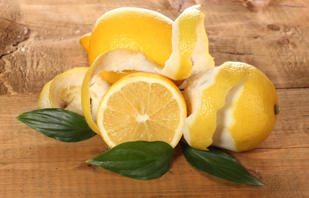 Ripe lemons with leaves on wooden table