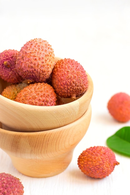 ripe lychees in a bowl on a white background closeup, selective focus