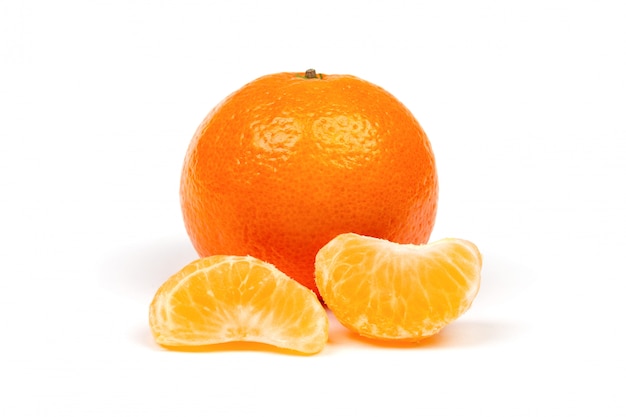 Ripe mandarine in peel and peeled tangerine slices close-up isolated