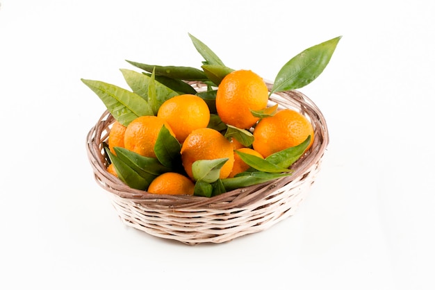 Ripe mandarines with leaves close-up on a white background. Tangerines with leaves on a white background.