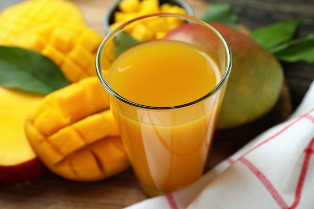 Ripe mango fruit and juice on wooden table