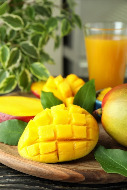 Ripe mango fruit and juice on wooden table