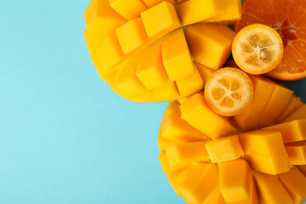 Photo ripe mango and orange on blue background.