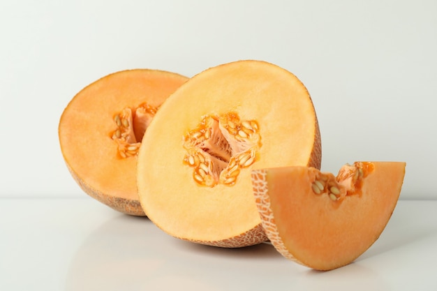 Ripe melon slices on white table, close up