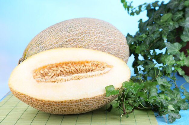 Ripe melons on wooden table on blue background