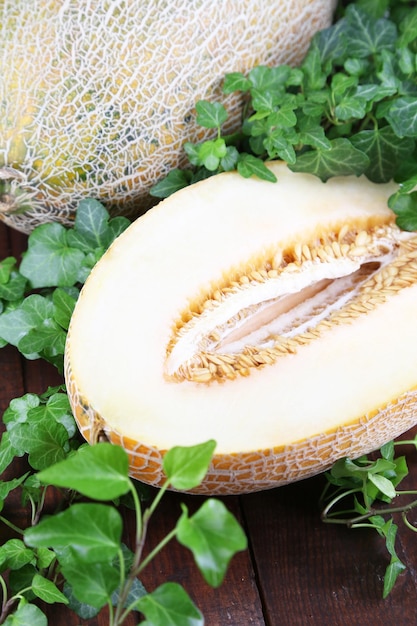 Photo ripe melons on wooden table closeup