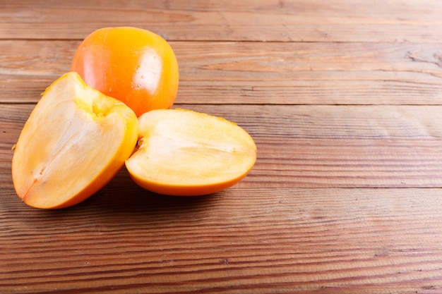 Ripe orange persimmon on brown wood