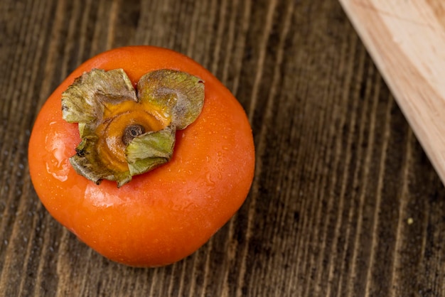 Ripe orange persimmon covered with drops