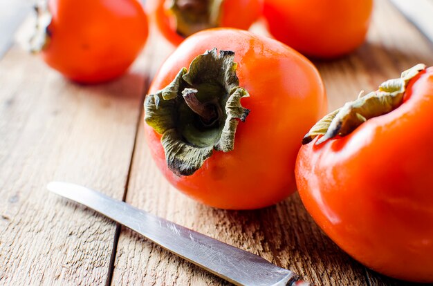 Ripe orange persimmons on an old wooden table