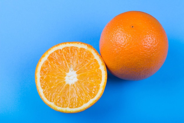 Ripe oranges on blue background