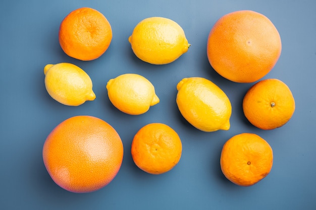 Ripe organic  citrus fruits set, on blue textured summer background, top view flat lay