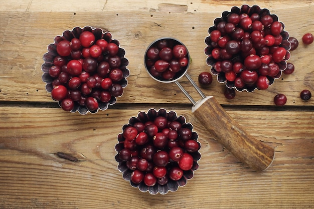 Ripe organic cranberry on rustic wooden table fresh berries in bowls autumn harvest concept