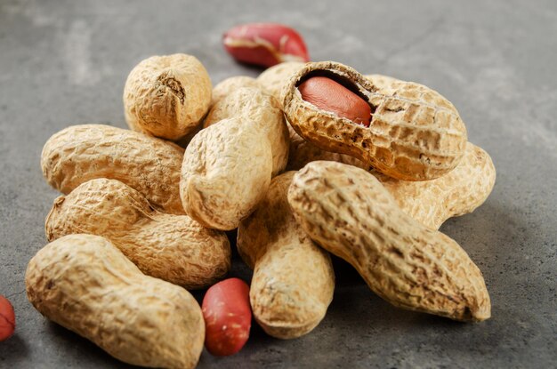 Ripe organic Peanuts in shell on stone table. Healthy eating concept