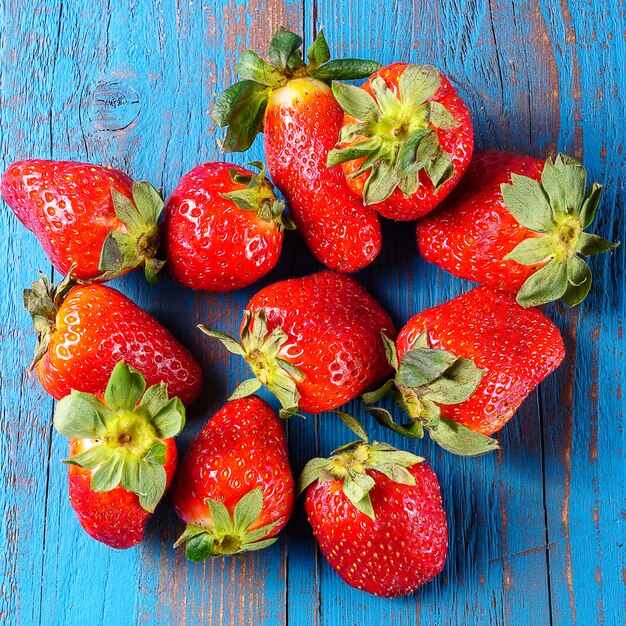 Ripe organic strawberries on wooden background, close up.