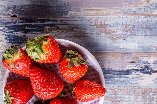 Ripe organic strawberries on wooden background, close up.