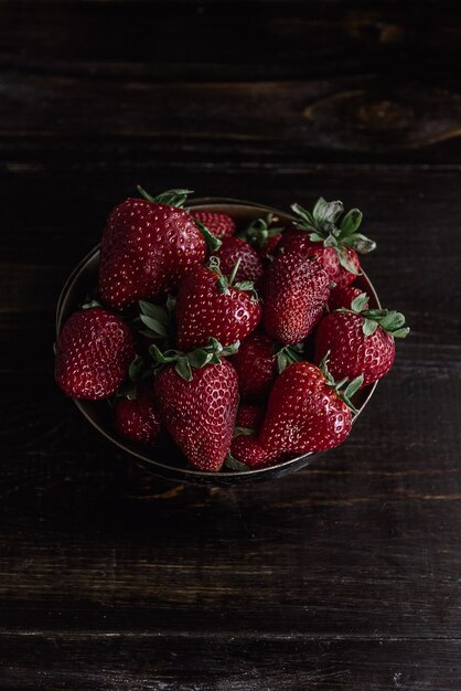 Ripe organic strawberry on a wooden background in a rustic style