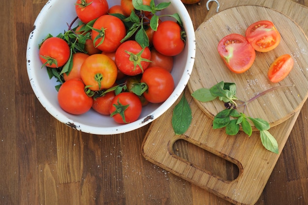 Ripe organic tomatoes in white bowl top view