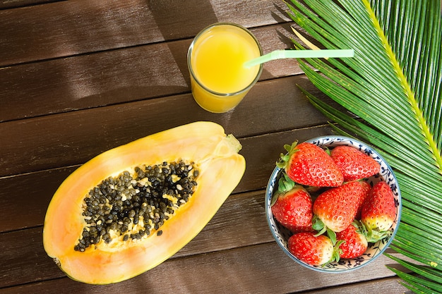 Photo ripe papaya fresh strawberries in bowl pineapple citrus juice