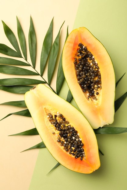 Ripe papaya with leaves on two tone background