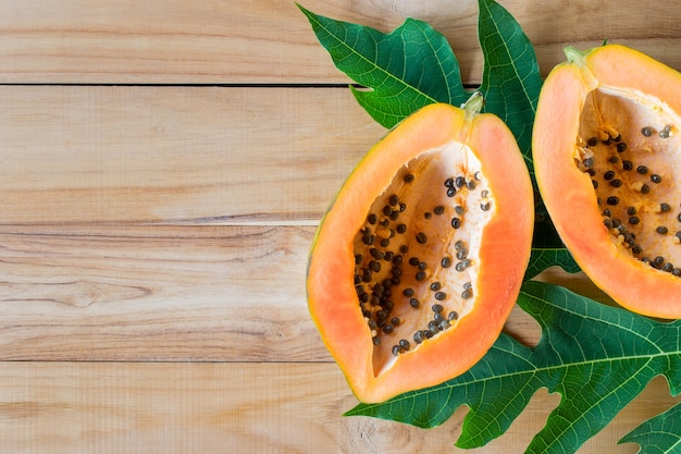 Ripe papaya on wood table from above .