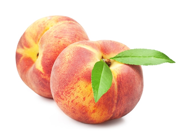 Фото Спелые плоды персика с листьями на белой поверхности