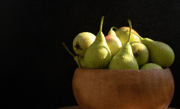 Ripe pear in a bowl on a black background