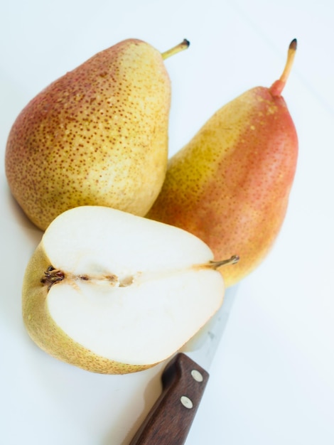 Ripe pear on white background. The cultivation of the pear in cool temperate climates extends to the remotest antiquity, and there is evidence of its use as a food since prehistoric times.