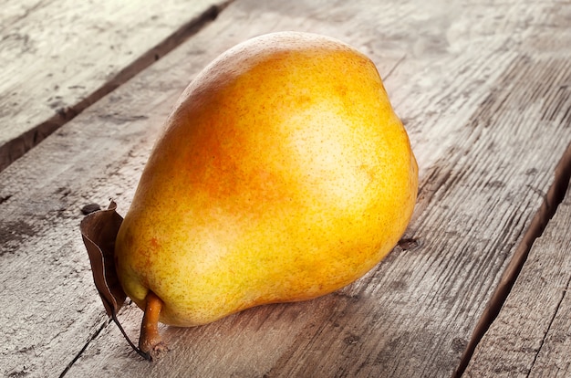 Photo ripe pear with dry leaf