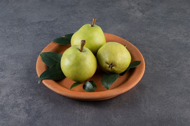 Ripe pears on a plate on the marble surface