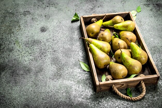 Pere mature sul vassoio sul tavolo rustico.