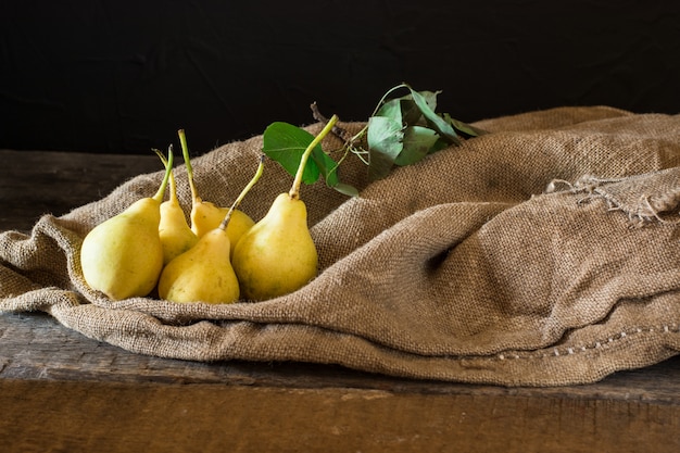 Photo ripe pears in a wooden box on the table. vegetarian, diet food. autumn harvest. juicy frui