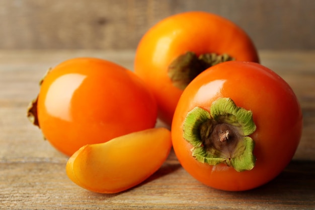 Ripe persimmon on color wooden background