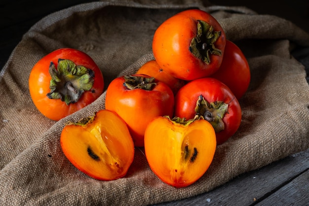 Persimmon maturo su fondo di legno dattero o frutta sharon kaki cachi frutta cibo locale