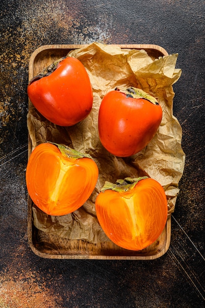Ripe  Persimmon on a wooden tray. Top view