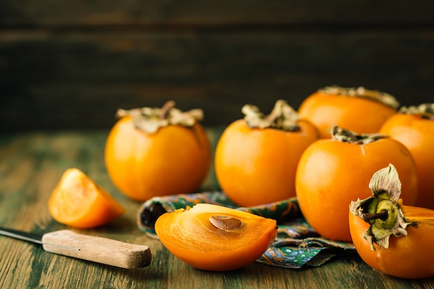 Ripe persimmons on a wooden background