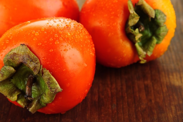 Ripe persimmons on wooden background